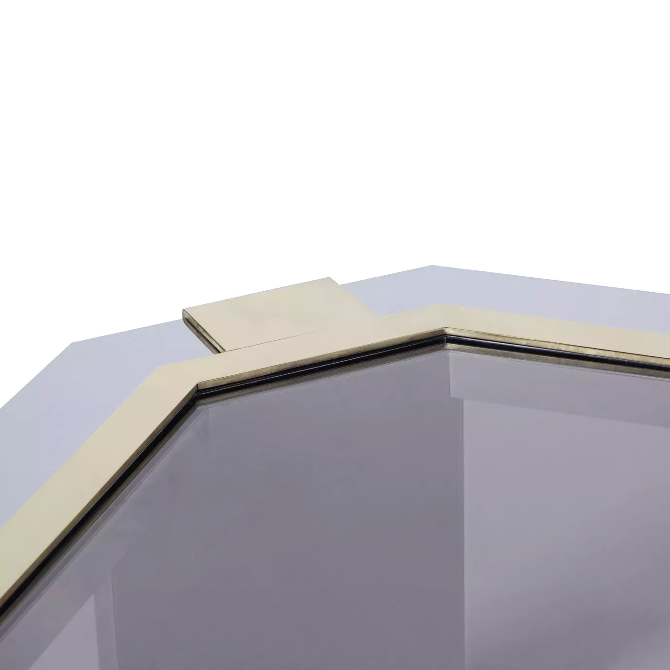 Elegant close-up of the dark glass top and geometric stainless steel frame with golden details of the Minx Coffee Table.