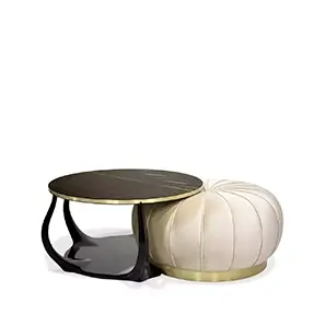 Elegant Embrace Cocktail Table with Sahara Noir marble top, glossy black base, and cream velvet pouf with golden detail.