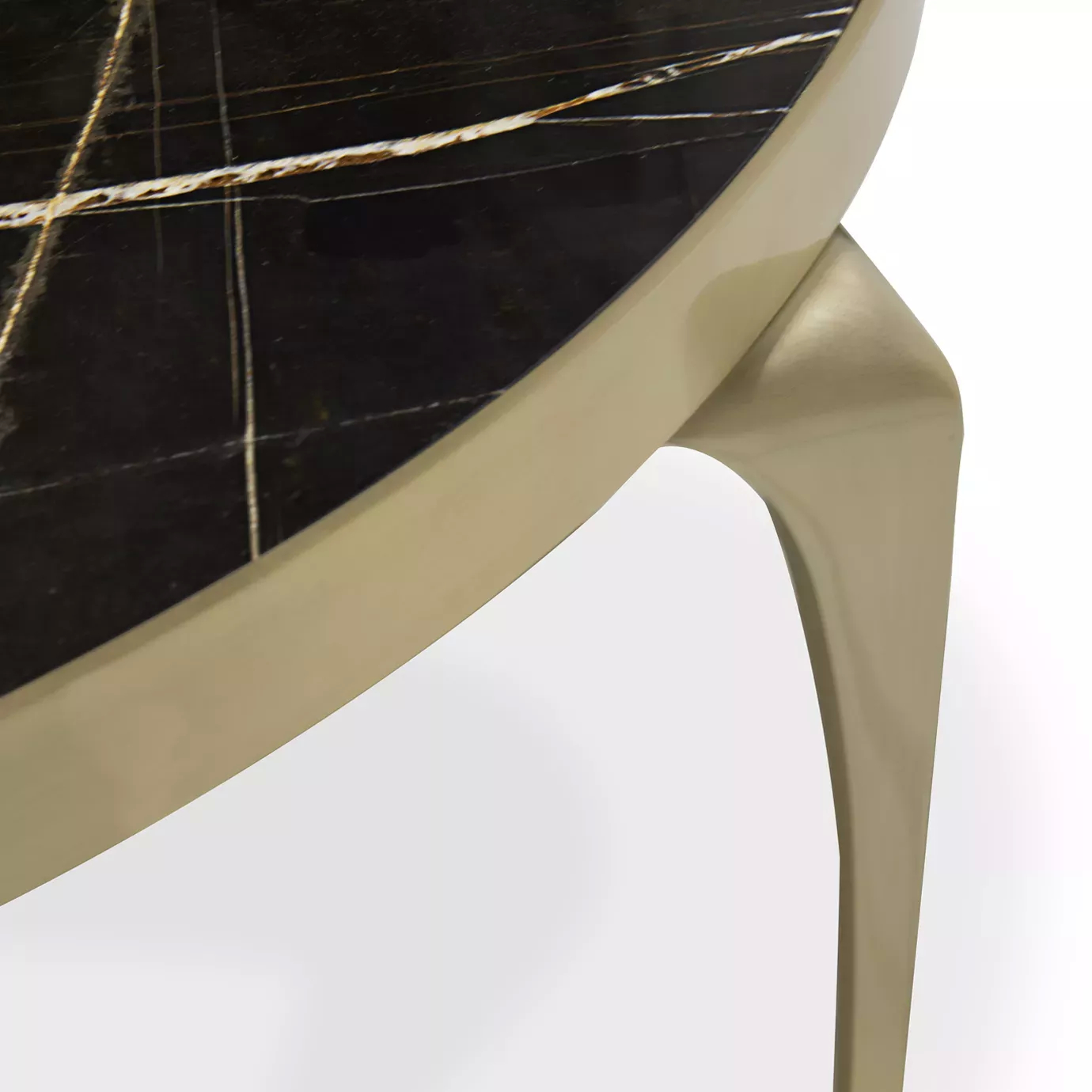 Elegant close-up of the Sahara Noir marble top and sculptural golden leg of the Rita table.