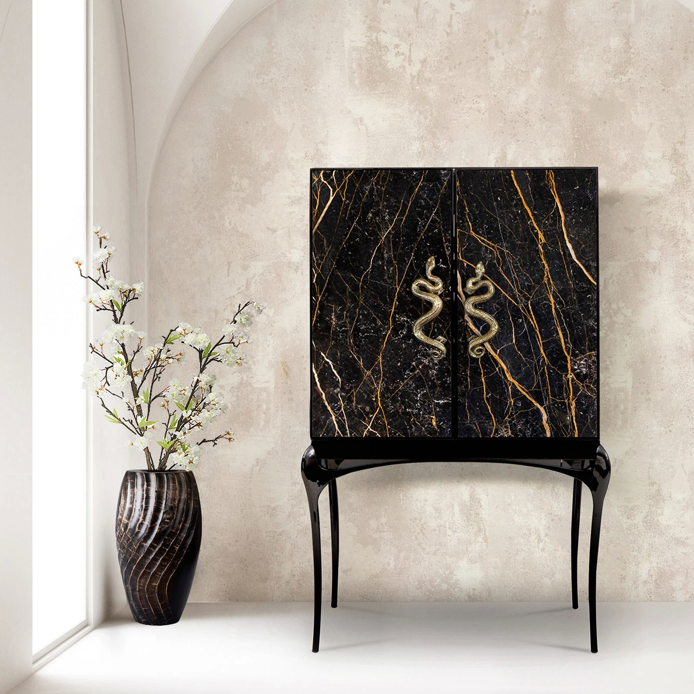 The India Port Laurent Marble Bar Cabinet, with its dramatic black and gold marble and serpent handles, adds a luxurious touch to this bright, minimalist room.