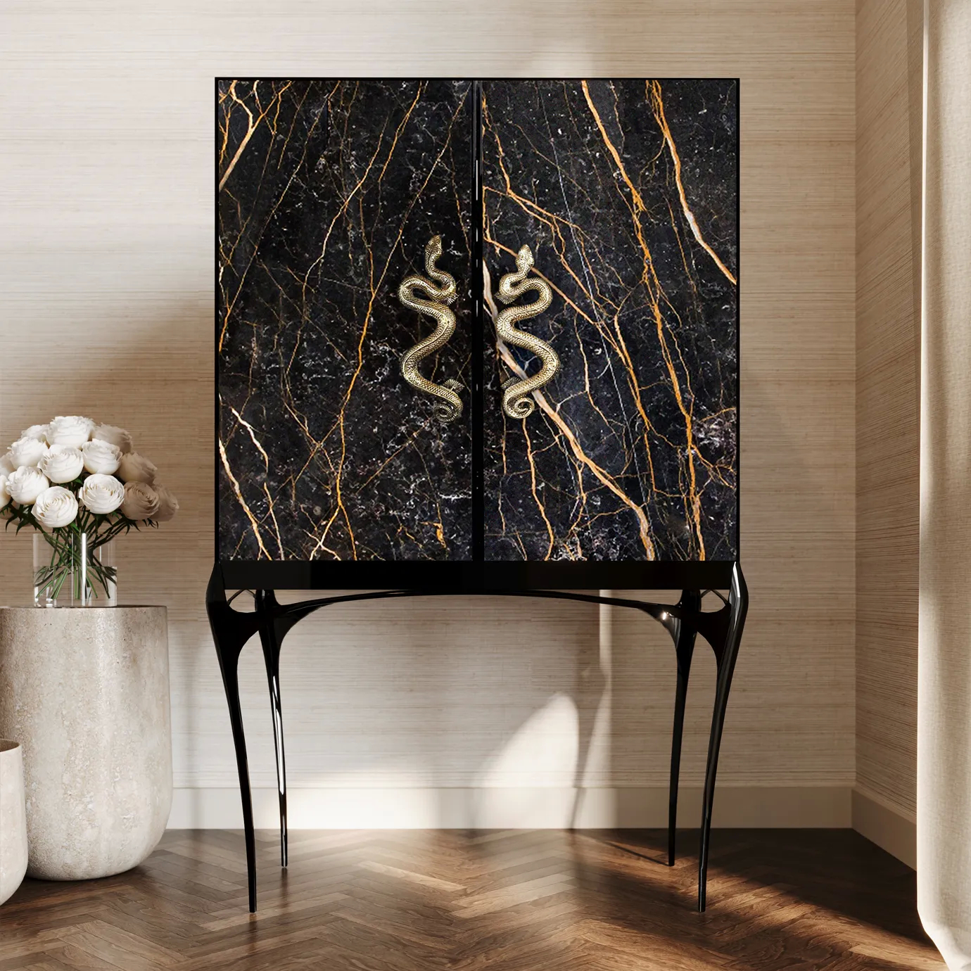 The India Port Laurent Marble Bar Cabinet stands elegantly in the room, its black and gold marble and serpent handles a luxurious focal point.