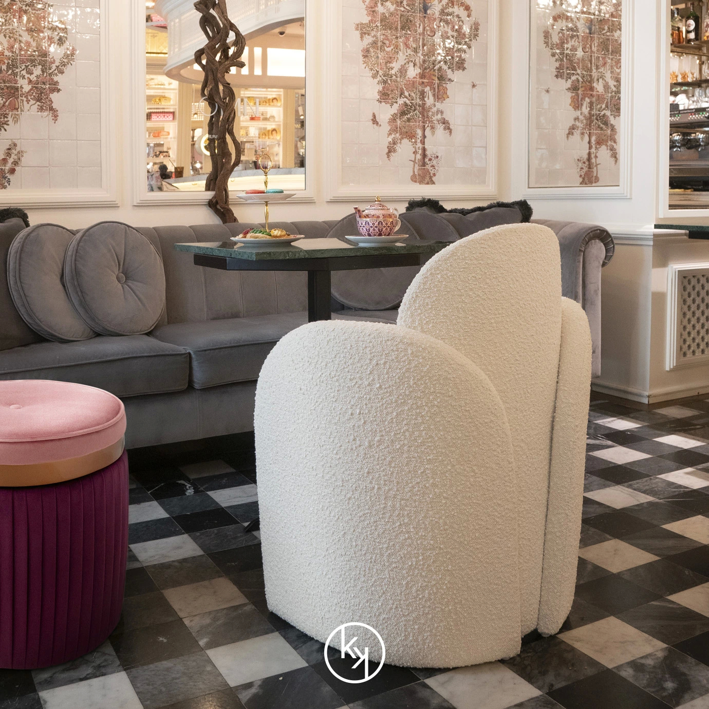 The Oh-lá-lá Chair, with its soft white texture and unique curves, adds a touch of modern comfort to the bar's stylish black and white floor.
