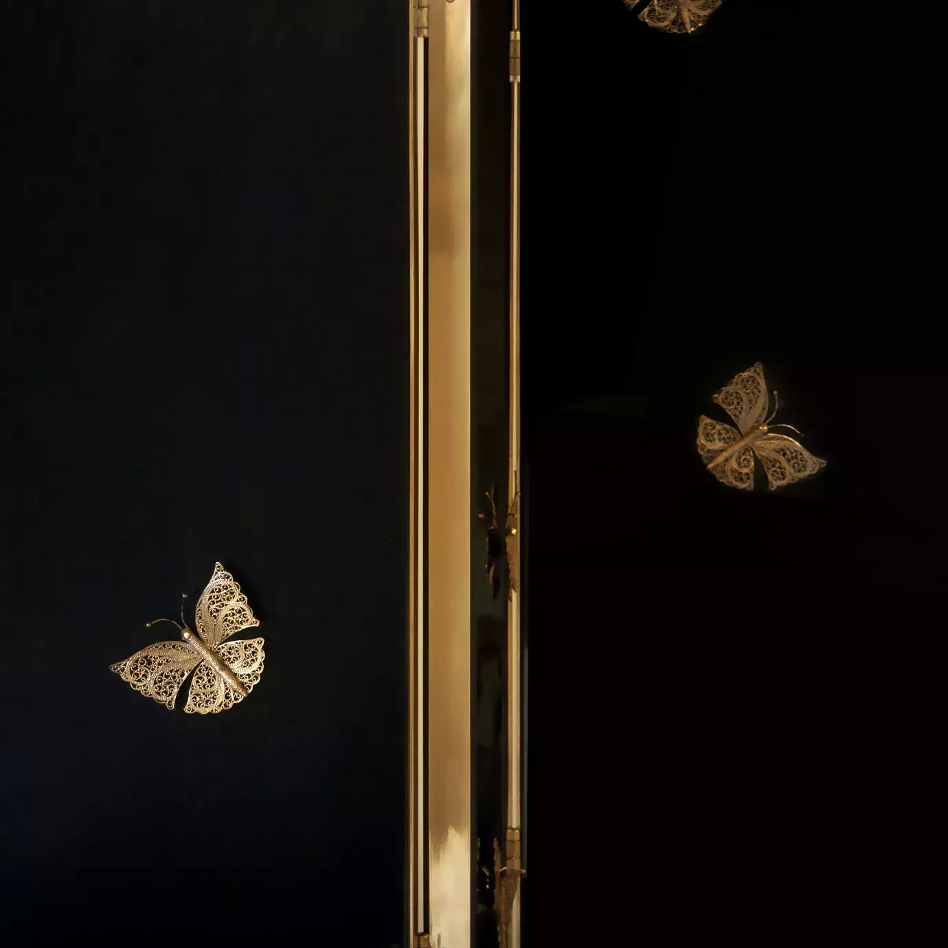 Detail of the Euphoria screen: black lacquer, golden metal frame, and delicate butterflies.