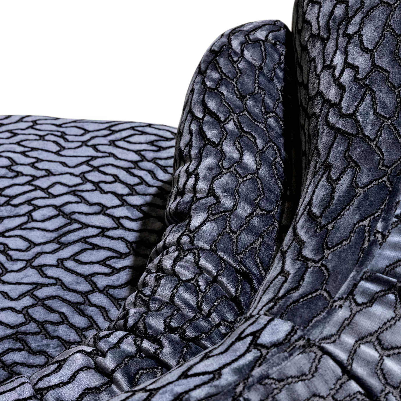 Close-up on the Deb Loveseat showcasing its distinctive textured upholstery and the soft folds of the draped fabric.