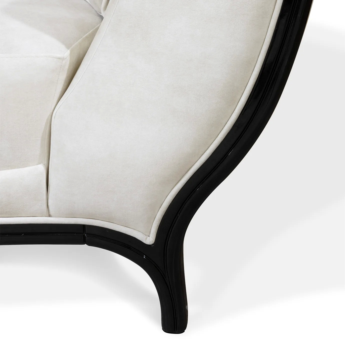Close-up of the Heavenly Sofa's elegant dark leg, showcasing its smooth curve and how it complements the light upholstery.