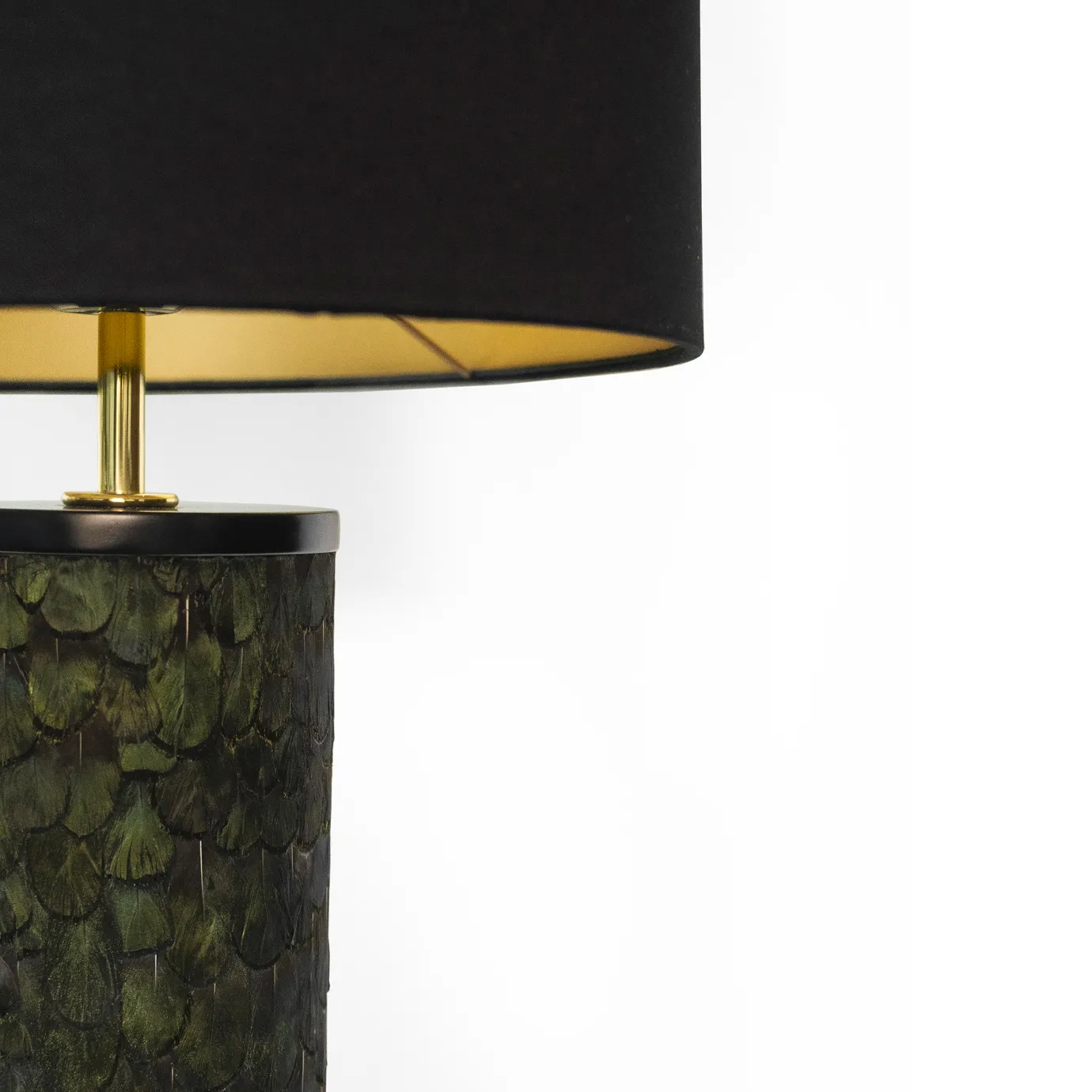 Close-up: green peacock feathers detail the base of the Tailor Peacock Feather Table Lamp with a black lampshade.