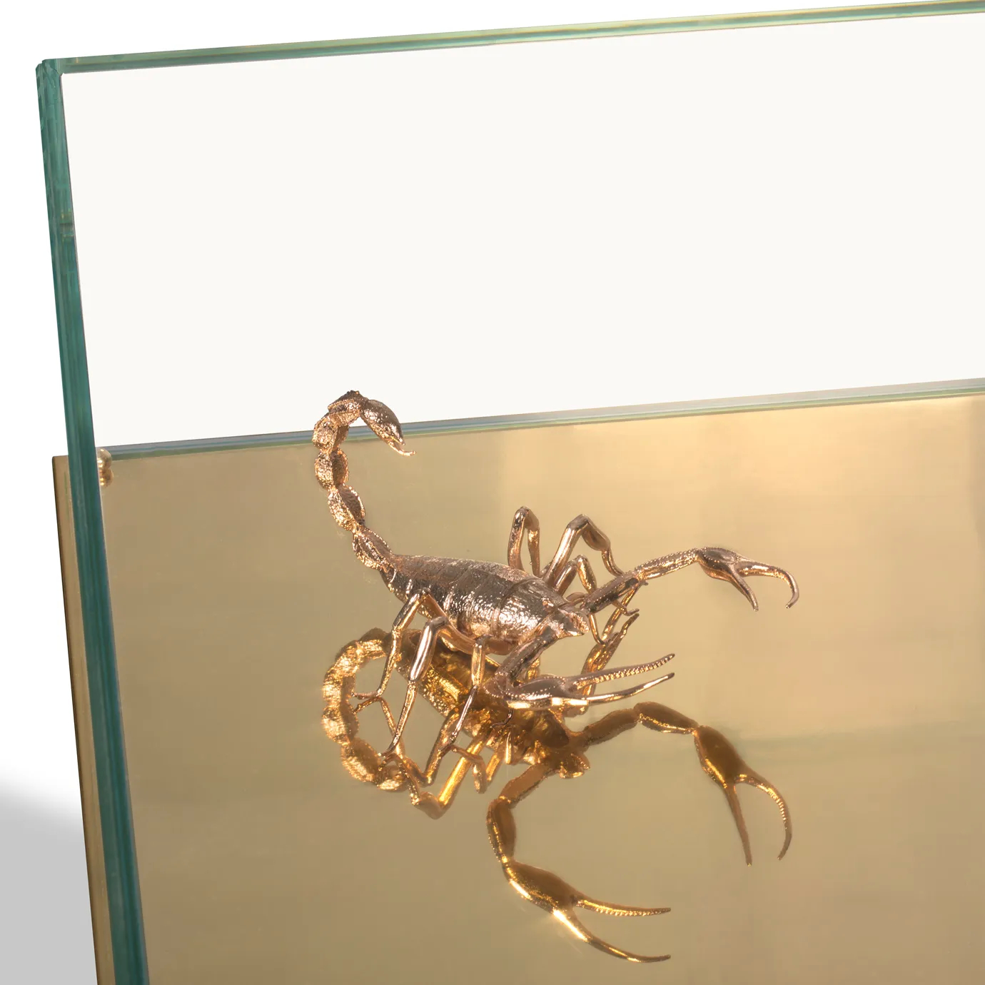 Close-up of a golden scorpion sculpture inside a mirrored glass Metamorphosis table.