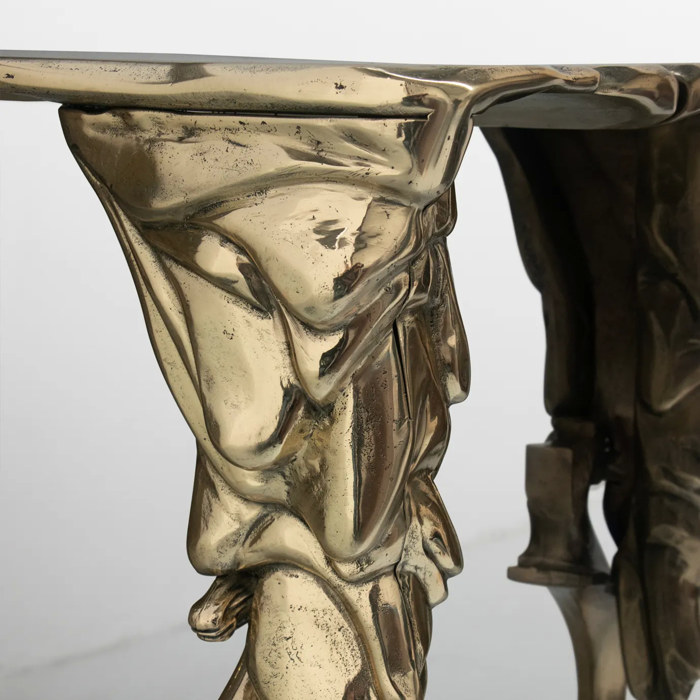 Close-up of Lumiere Console’s gold table surface, showcasing its sculptural design and reflective finish.