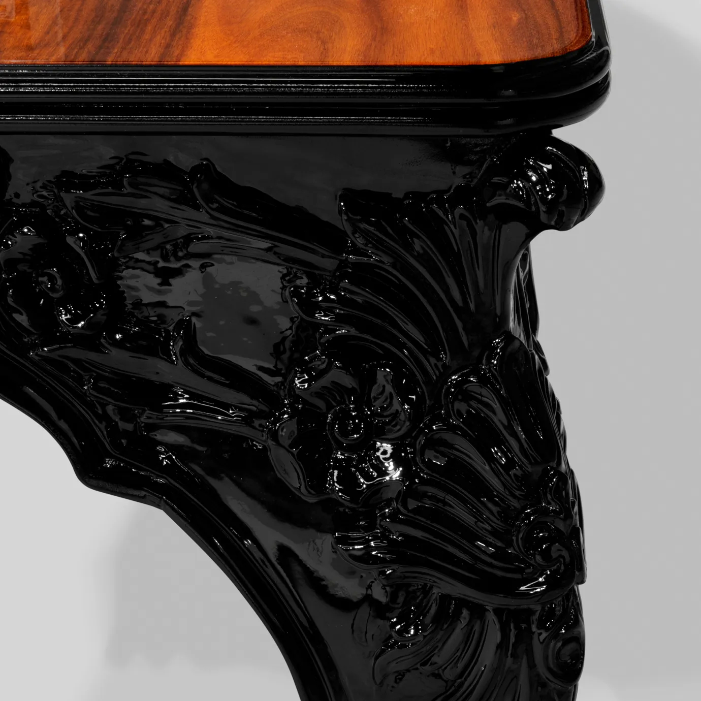 Close-up of the luxurious Royal Dining Table's ornate, glossy black leg.