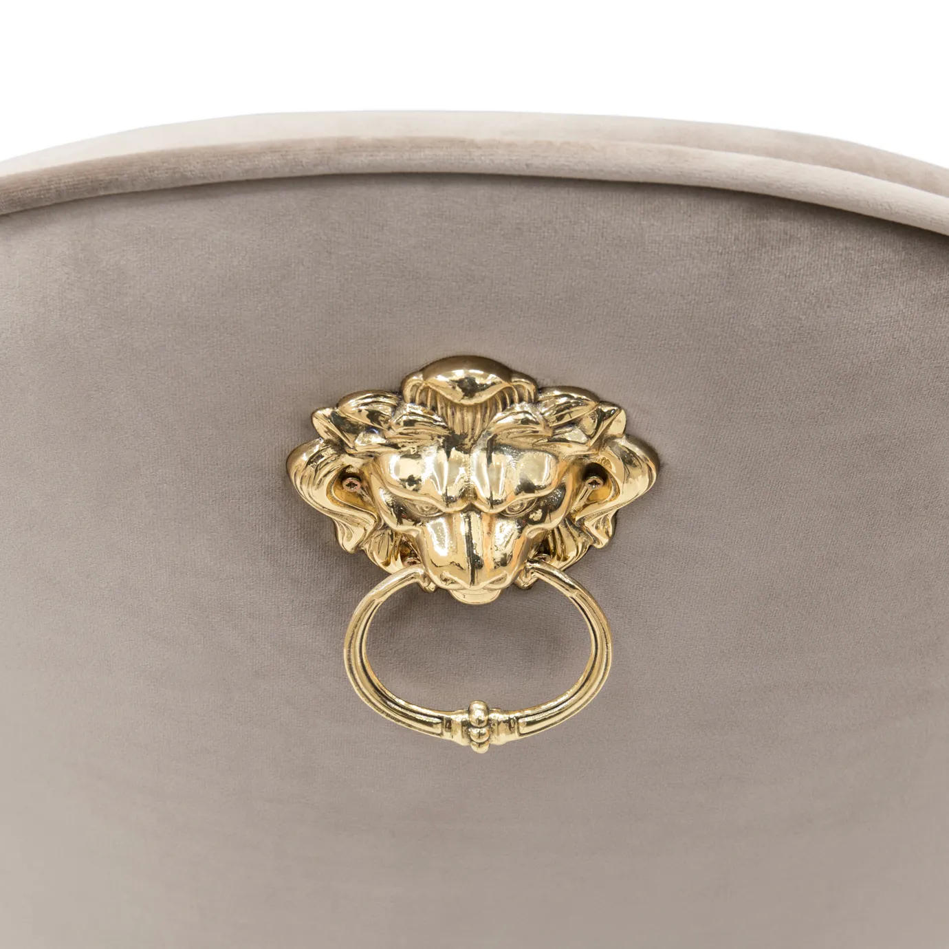 Cream velvet chair with curved backrest and polished brass legs.