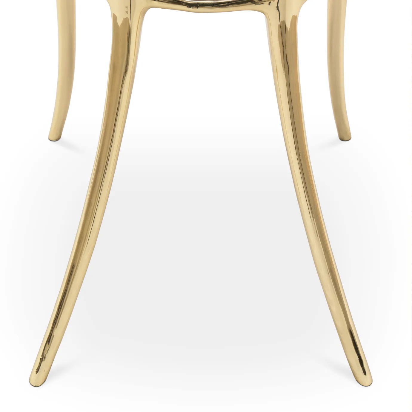 Close-up of polished brass leg with sculpted detail on cream Soleil chair.