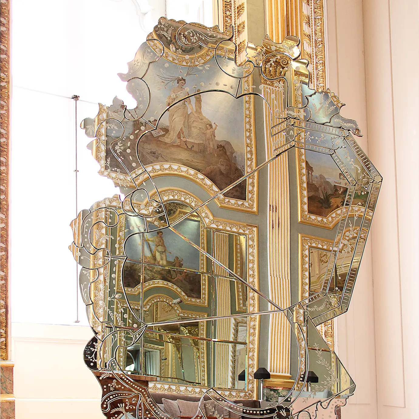 Venetian-style mirror with elaborate gold frame enhances a luxurious bedroom interior, reflecting timeless elegance and refined decorative design