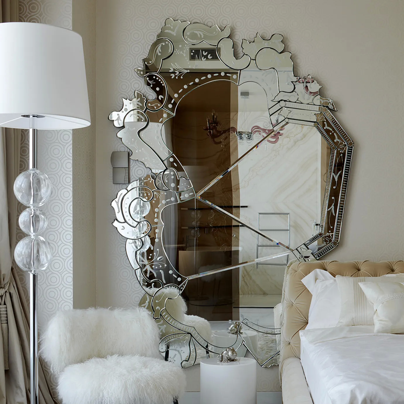 Venetian mirror with elaborate gold frame adds timeless elegance to a sophisticated bedroom setting, blending luxury with classic design