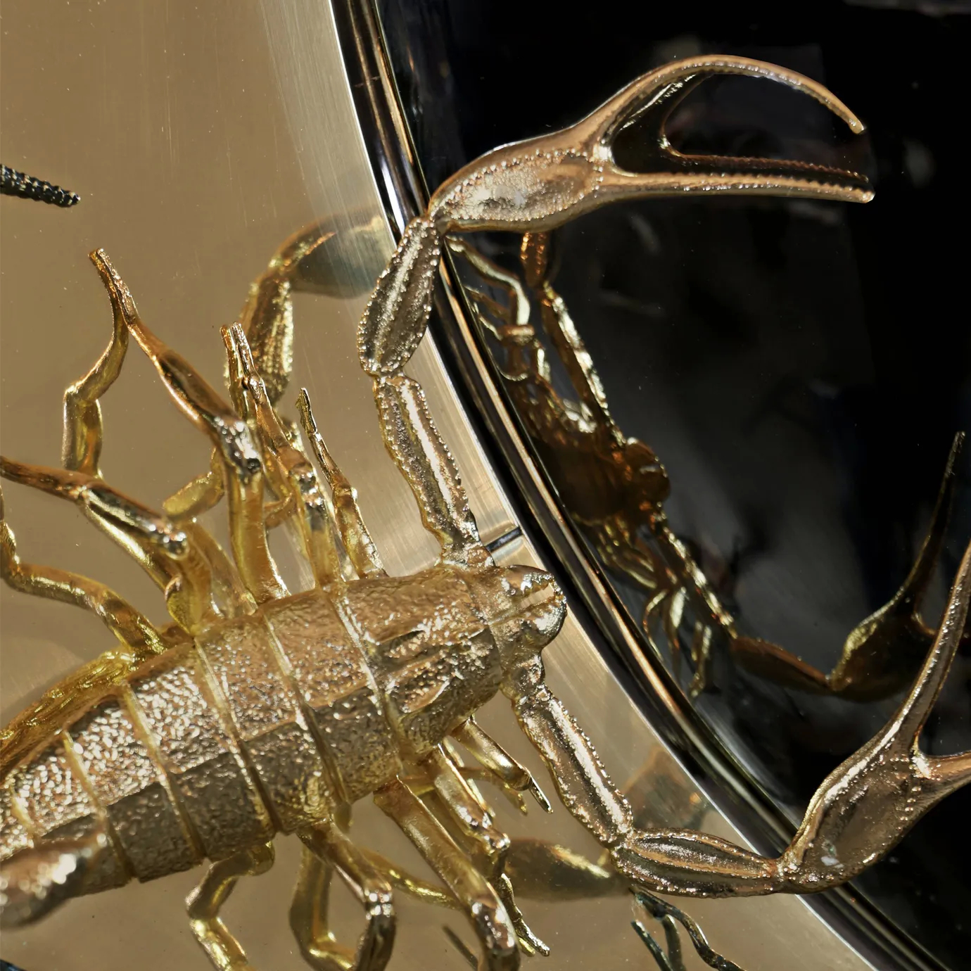 Close-up detail of the convex mirror’s edge with surrounding insect sculptures, showcasing craftsmanship and metallic finish in a nature-inspired design