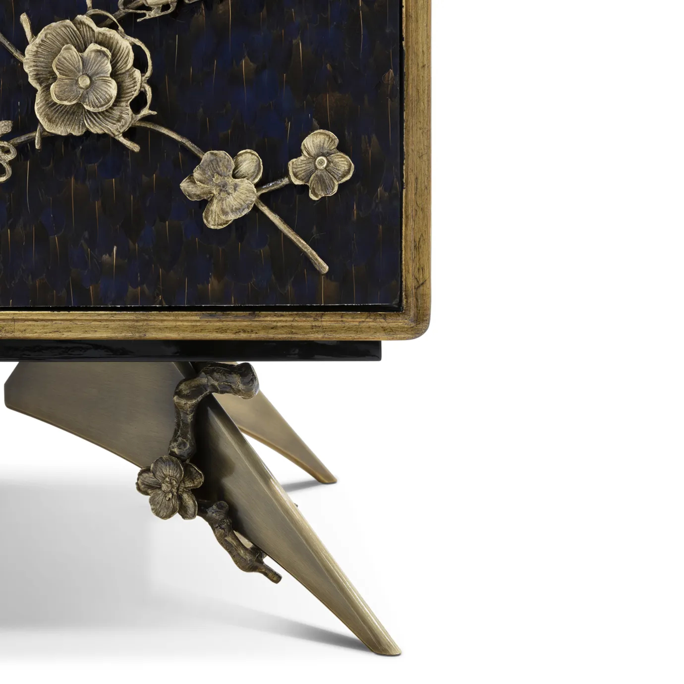 Detailed view of the feet of the Spellbound Purple Feather Cabinet, showcasing its golden details with the same floral motifs as placed on the doors, adorned with purple peacock feathers.
