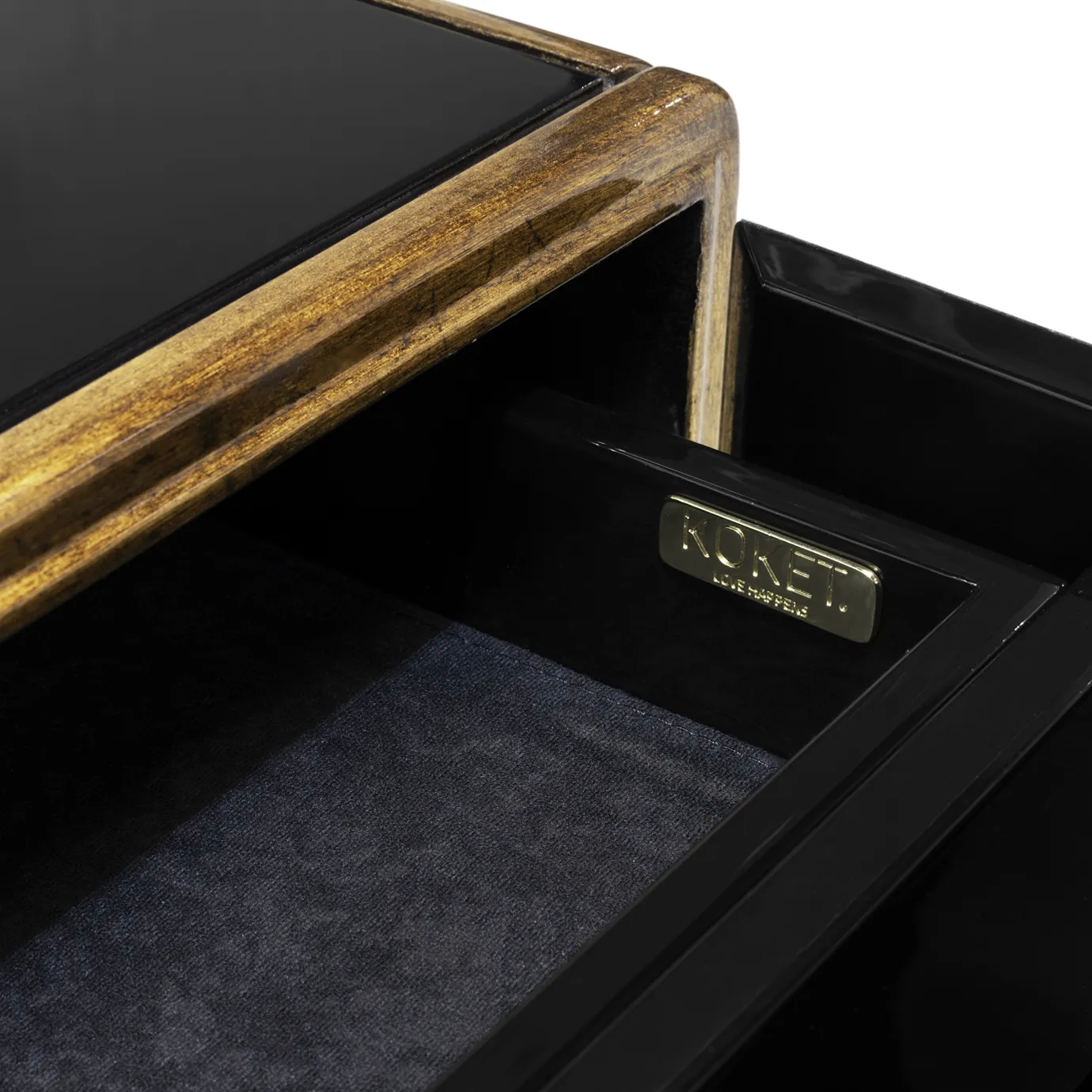 Interior view of the Spellbound Purple Feather Cabinet, showing its black drawers. Inside the drawer, there is a representation of KOKET’s logo.
