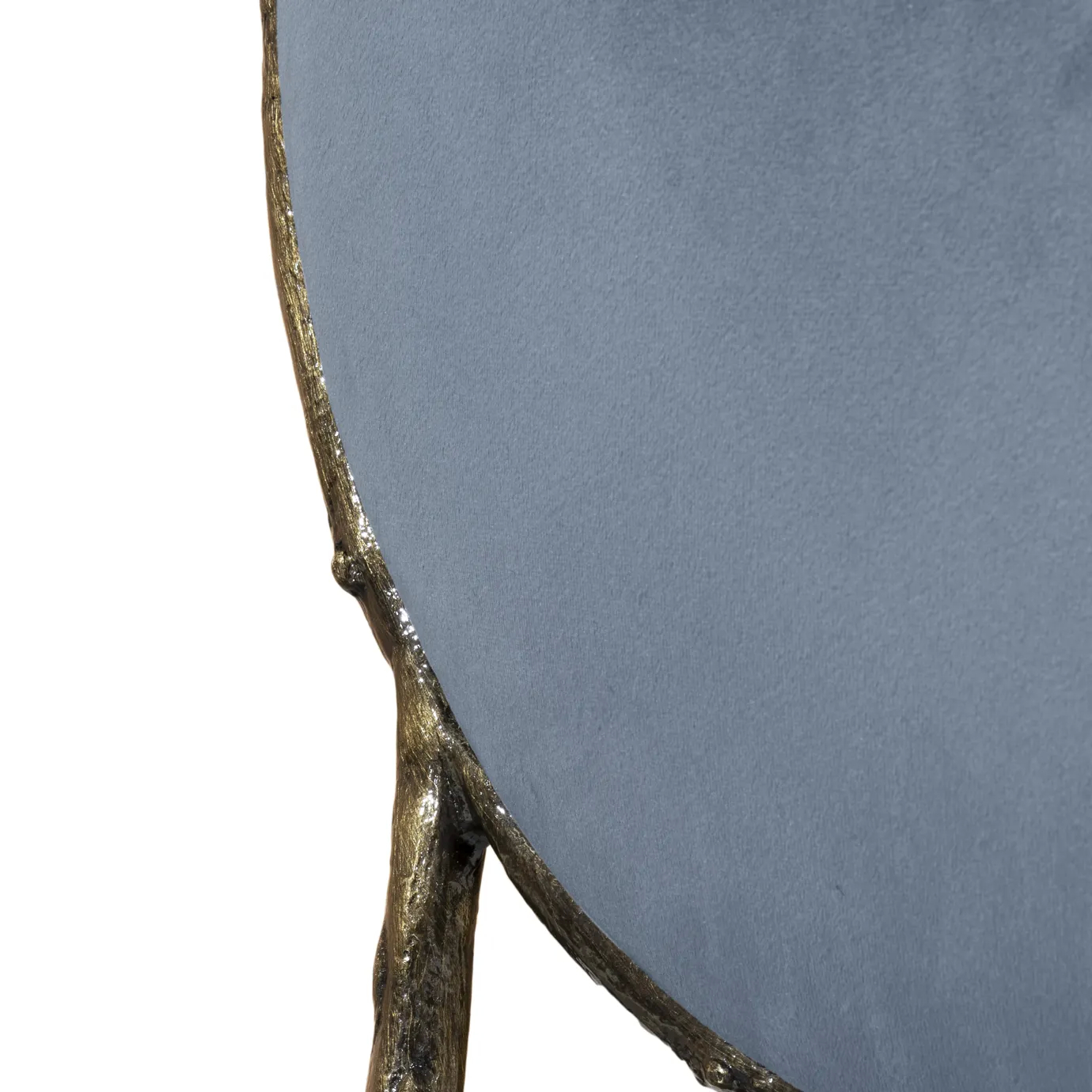 Close view of the Enchanted Dining Chair’s aged brass frame, combining with the luxurious blue upholstery.