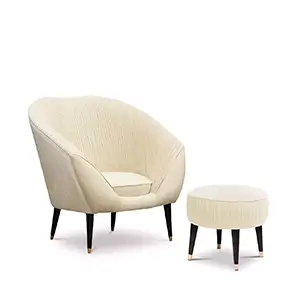Elegant Audrey Chair in cream fabric with pleated details and matching footrest with black legs and golden details.