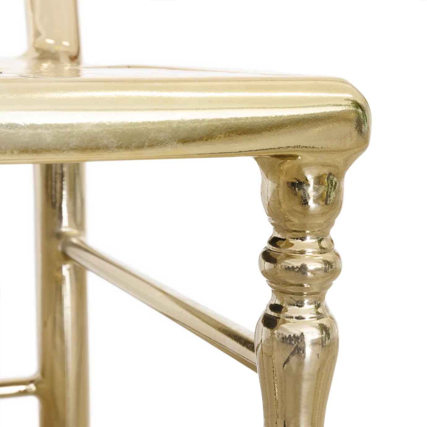 Chic gold chair with a modern, curved backrest and refined, luxurious design details.