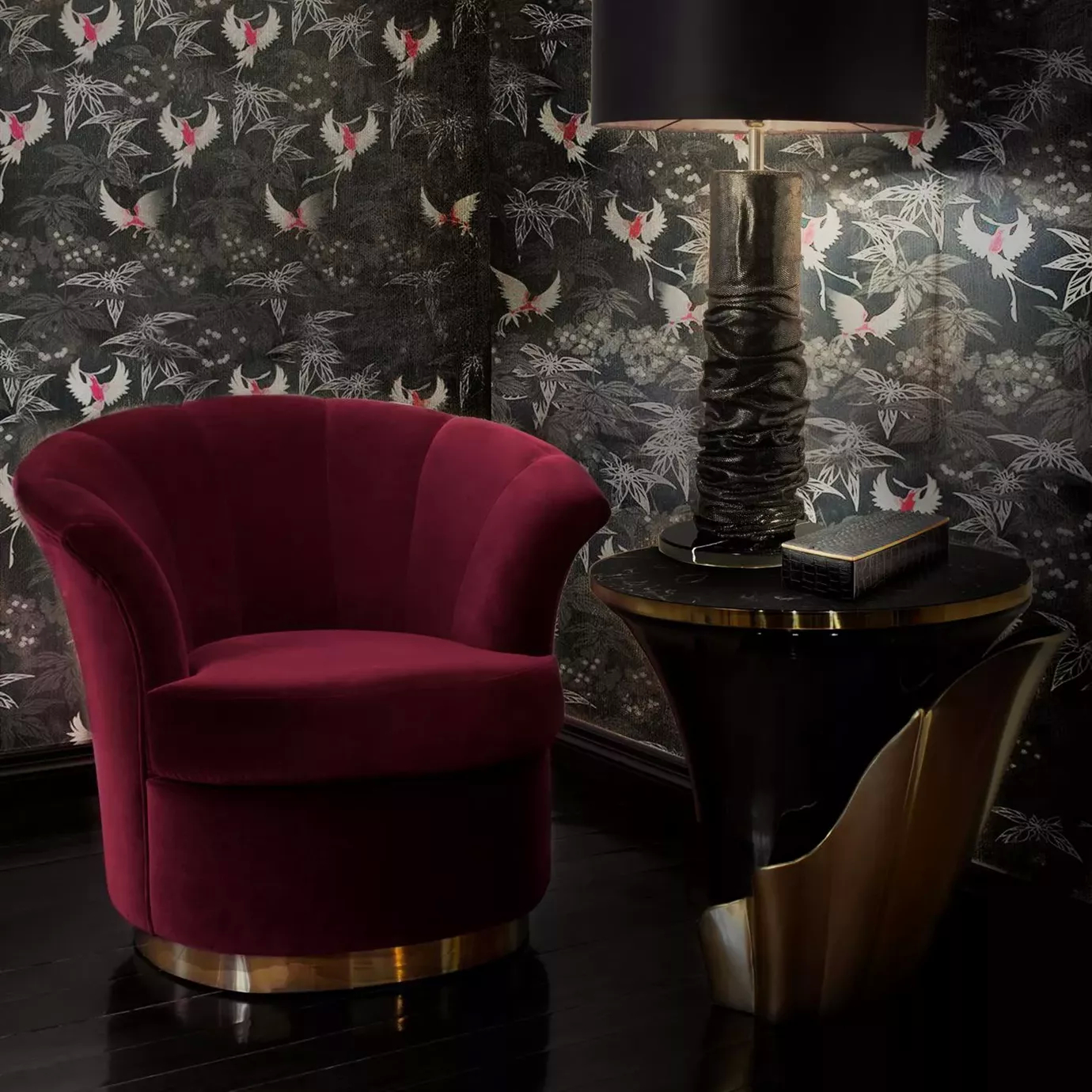 Elegant Besame Chair with golden base and deep red velvet upholstery next to a Yasmine side table with black marble top.