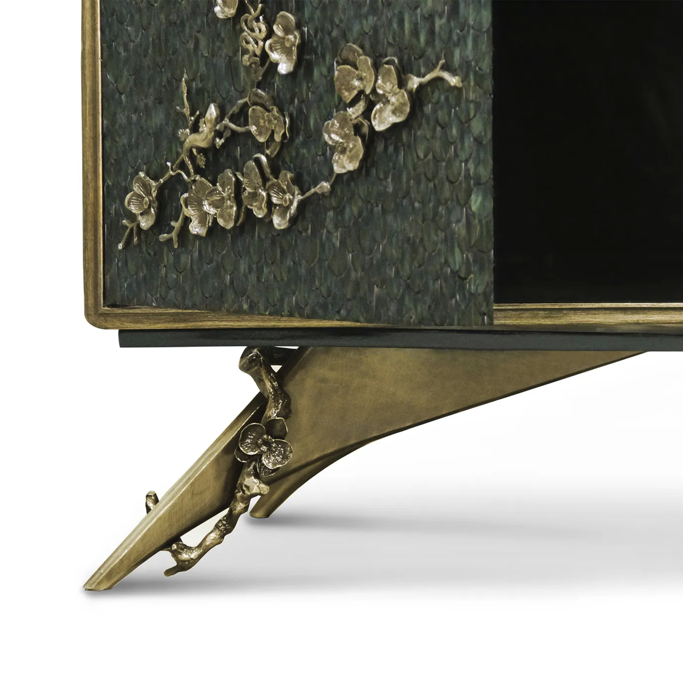 Detailed view of the feet of the Spellbound Peacock Feather Cabinet, showcasing its golden details with the same floral motifs as placed on the doors, adorned with greenish peacock feathers.