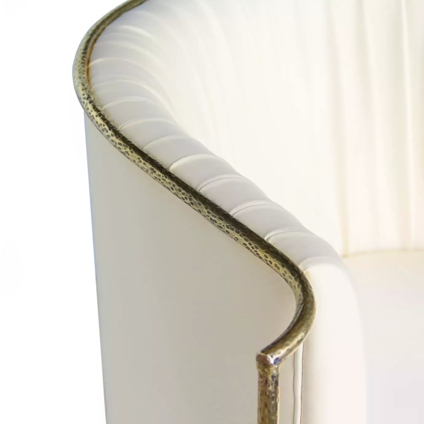 Elegant close-up of the golden metal frame and cream fabric upholstery with pleated details of the Desire Chair.