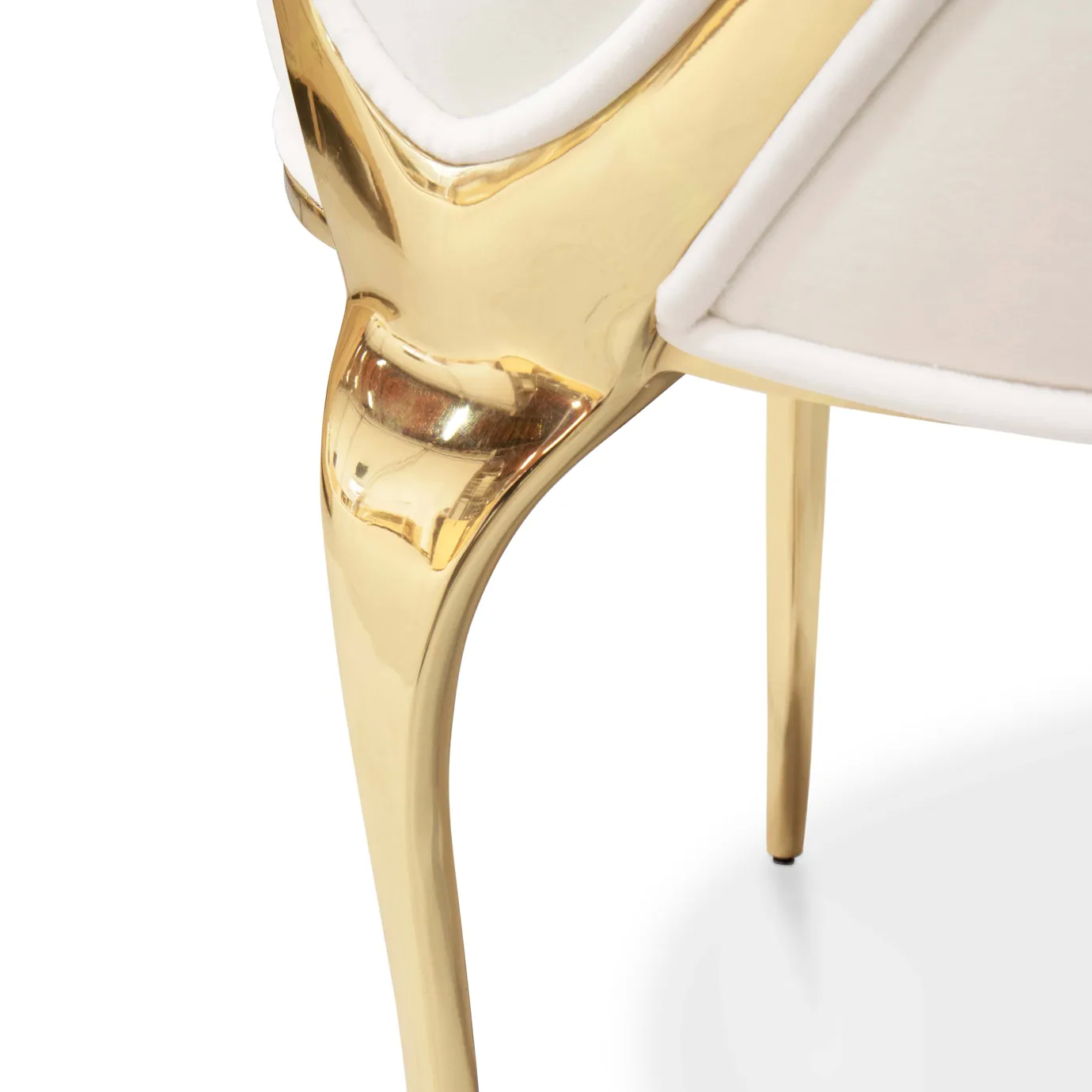 Detail view of the Chandra Dining Chair in white by KOKET, highlighting the seamless join between the plush seat cushion and the polished brass frame.