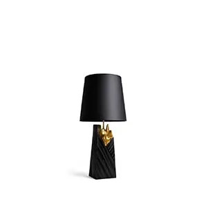 A luxurious Gild Table Lamp featuring a black conical shade, a golden organic-shaped stem, and a textured black trapezoidal base, on white.