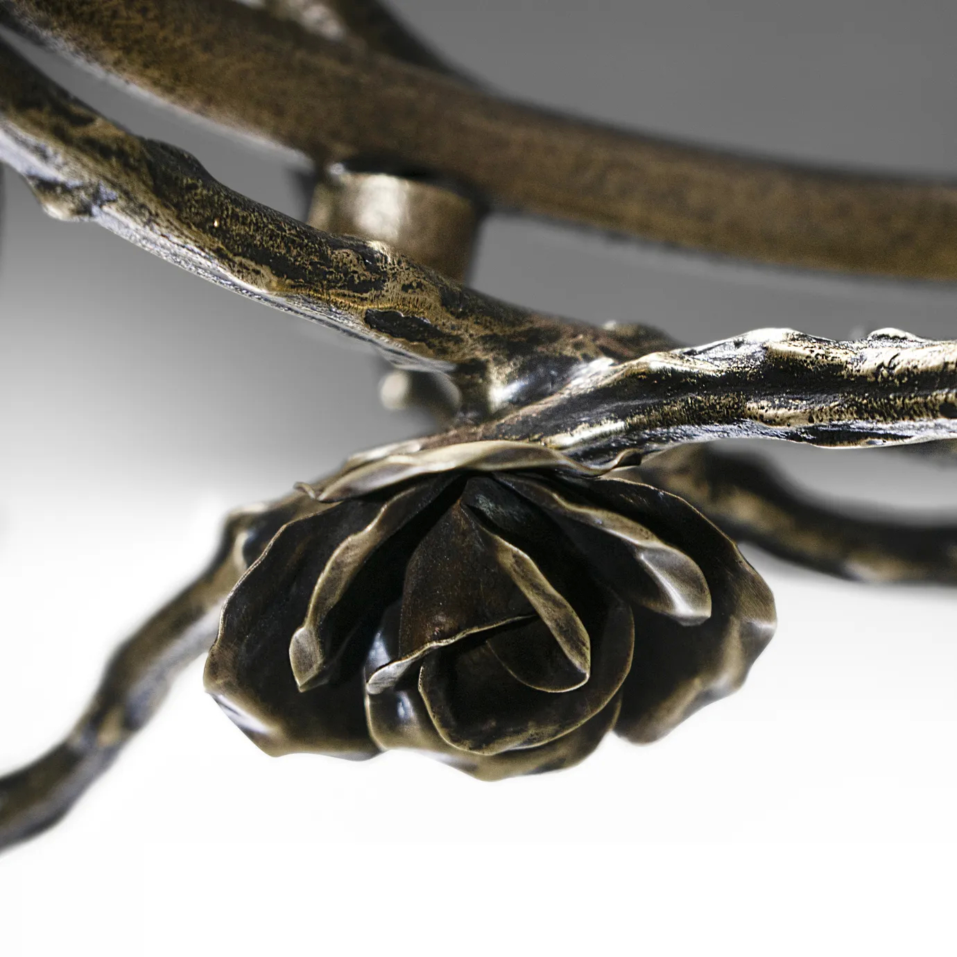 Close-up of the Rose Chandelier in aged brass, showcasing sculpted rose and branch elements with antique finish and intricate metalwork craftsmanship.