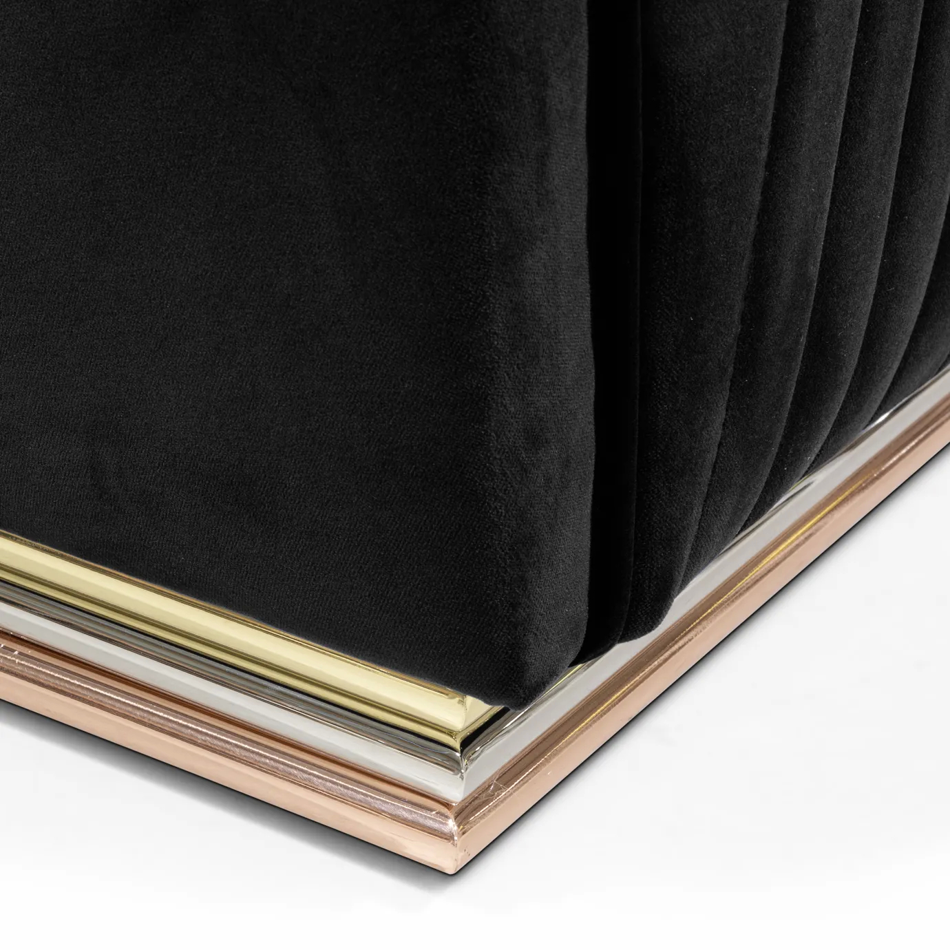 Elegant close-up of the base with brass finishes and the black velvet with pleated detail of the Mia Armchair.