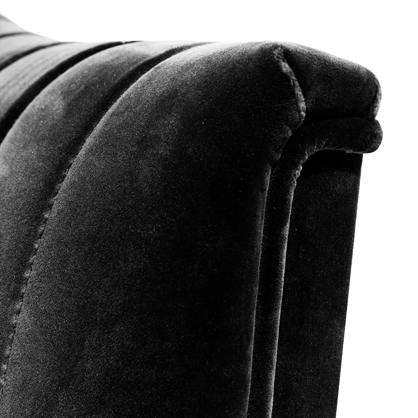 Elegant close-up of the pleated detail of the black velvet of the Mia Armchair.