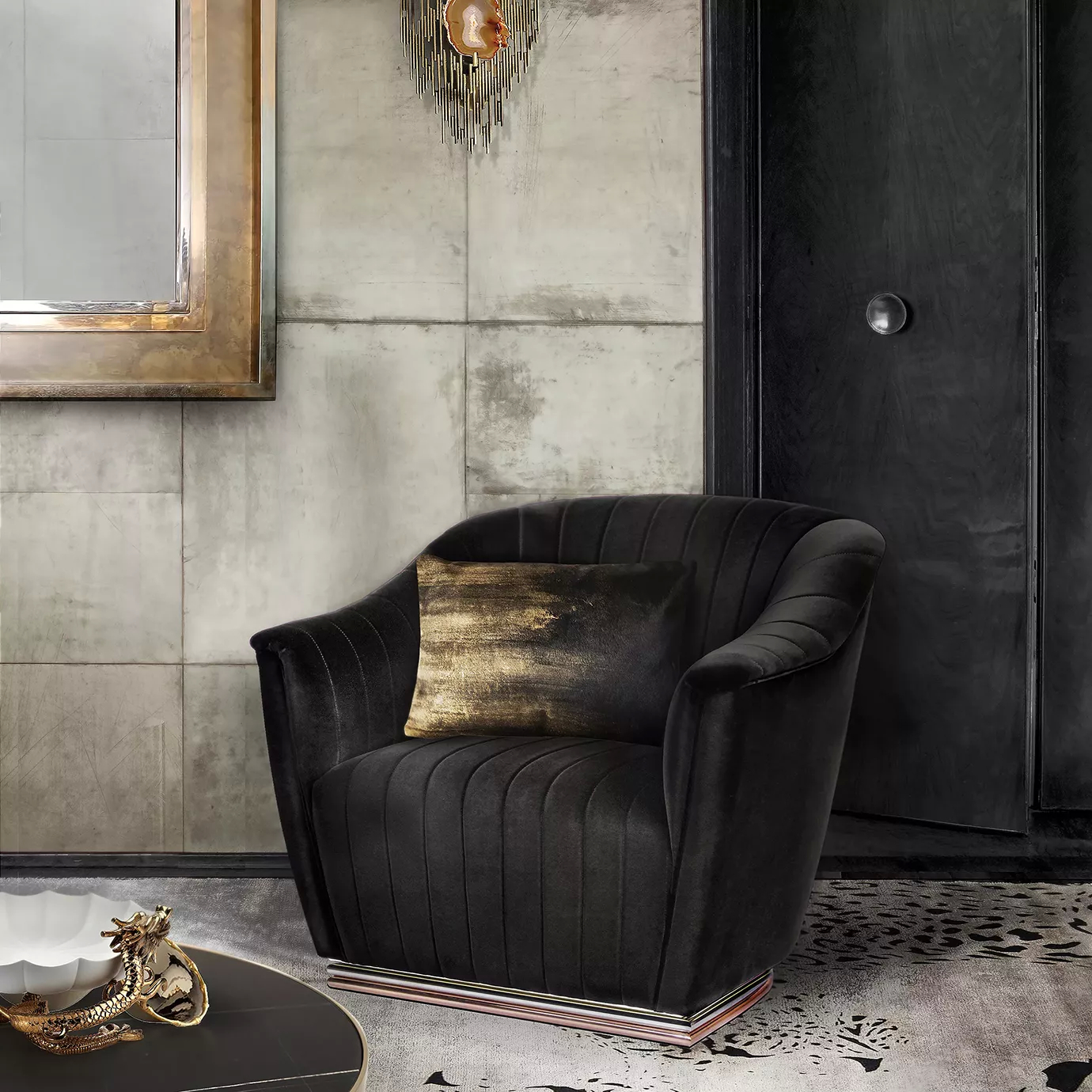 Elegant Mia Armchair upholstered in black velvet with pleated details and a golden cushion in a sophisticated interior.