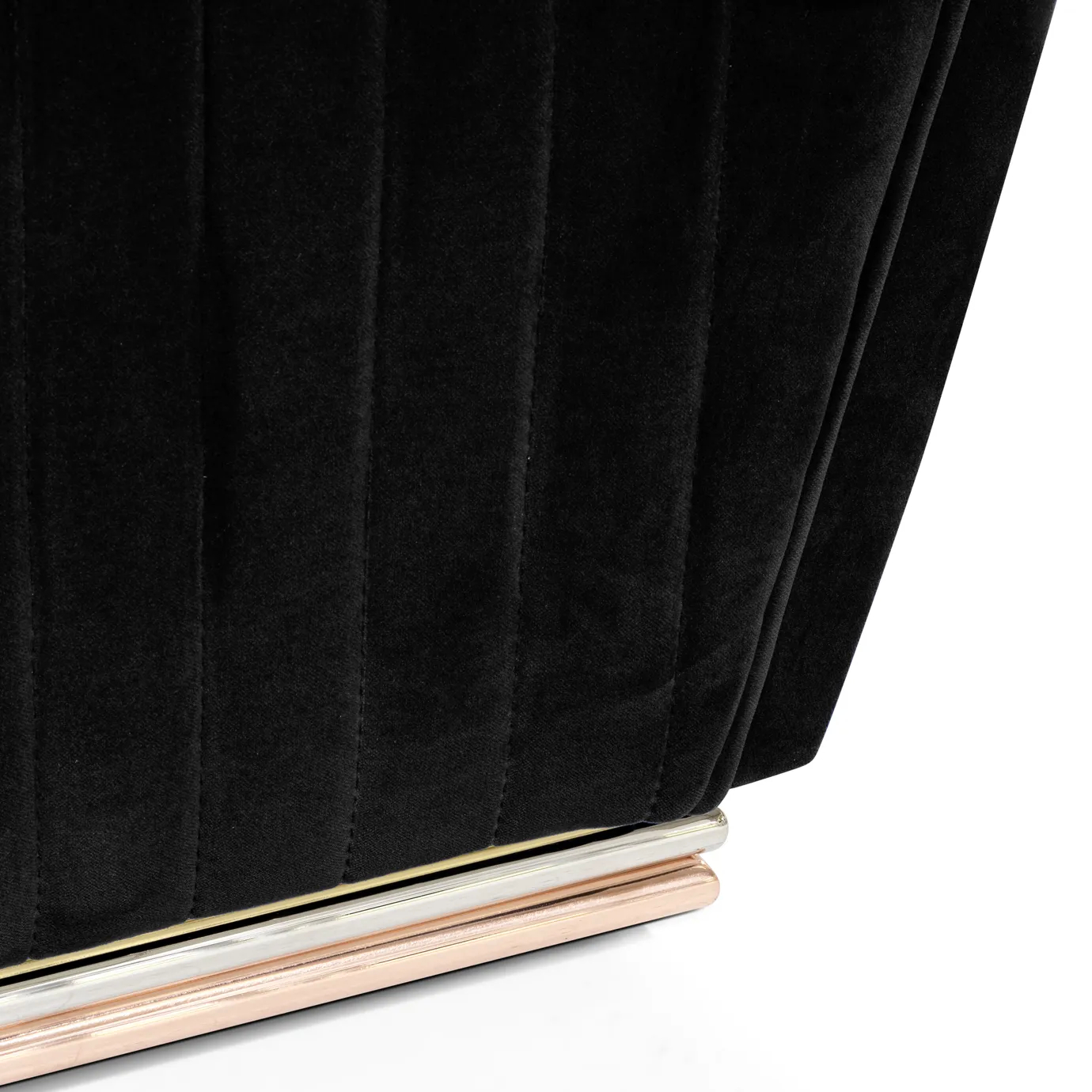 Elegant close-up of the base with brass finishes and the black velvet with pleated detail of the Mia Armchair.