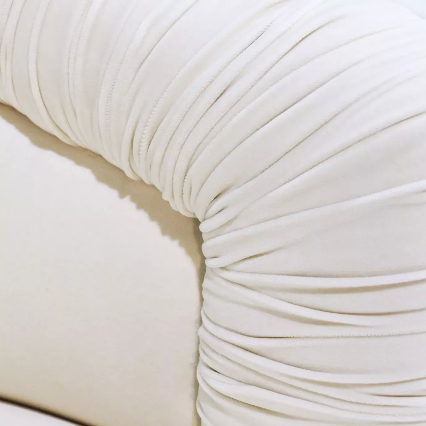 Elegant close-up of the ruched detail of the cream fabric of the Lovely Armchair
