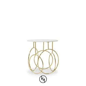 Elegant Kiki Side Table with round top and sculptural golden base.