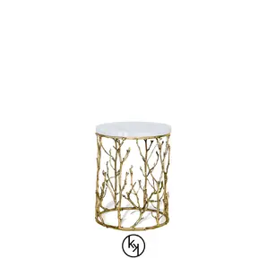 Featuring a white tabletop, the Enchanted Carrara Marble Side Table has a structure adorned with intricate aged brass details, resembling branches.