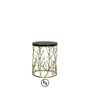 Featuring a dark tabletop, the Enchanted Nero Marquina Marble Side Table has a structure adorned with intricate aged brass details, resembling branches.