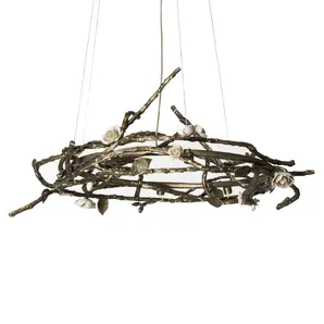 Rose Round Chandelier in aged brass with sculptural branches, metallic leaves, and cream rose-shaped accents, suspended by thin wires in a modern interior.