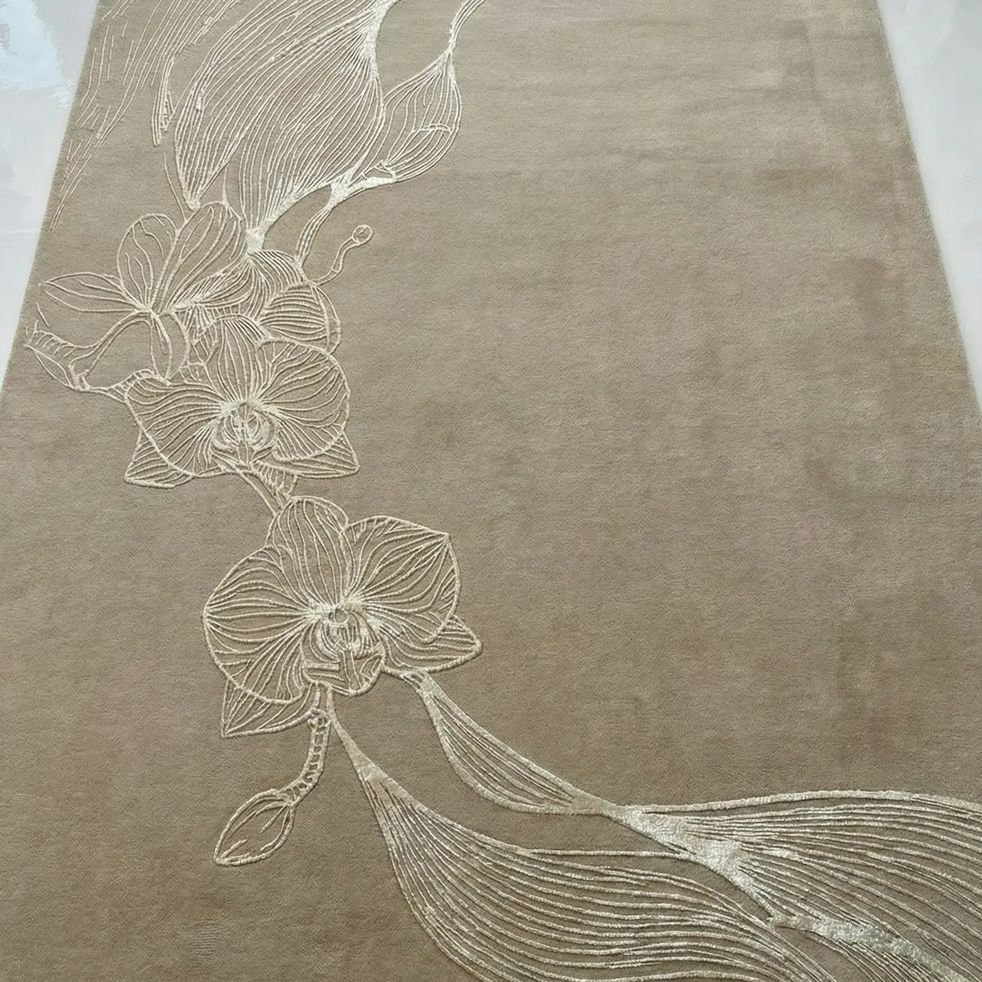 KOKET Orchid Sand Rug with sculpted orchid motif in ivory relief on a warm sand-toned wool base