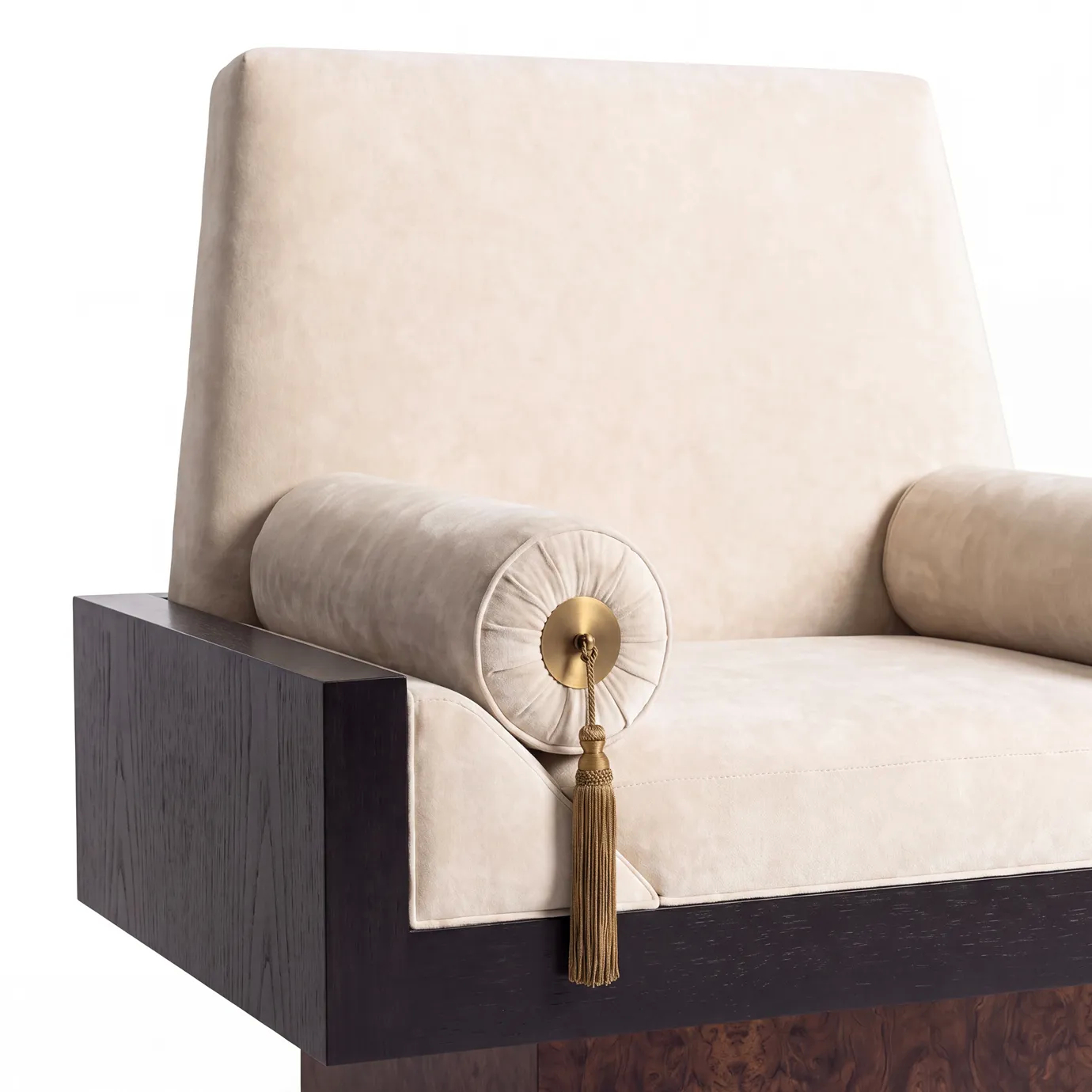Detail of Lola armchair by KOKET, cream velvet bolster with a polished brass medallion and gold tassel on a black lacquer arm.