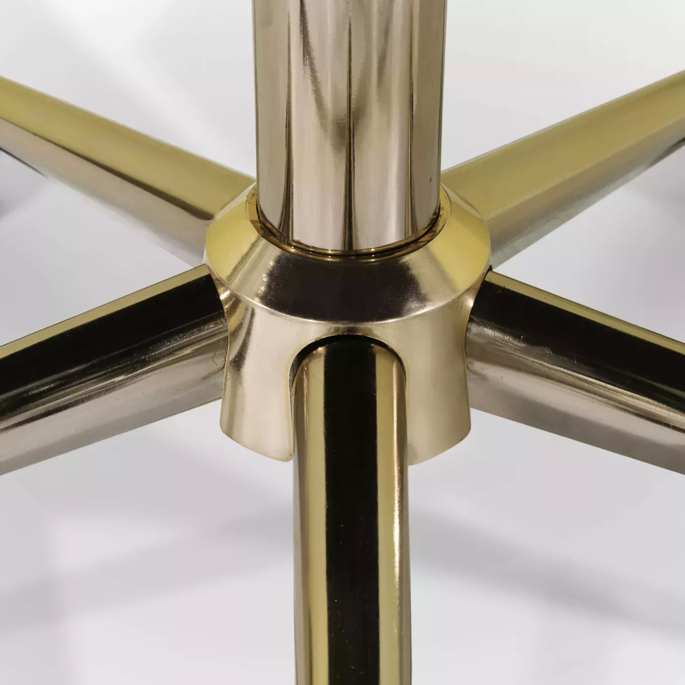 Elegant close-up of the golden swivel base of the Hemma Office Chair.