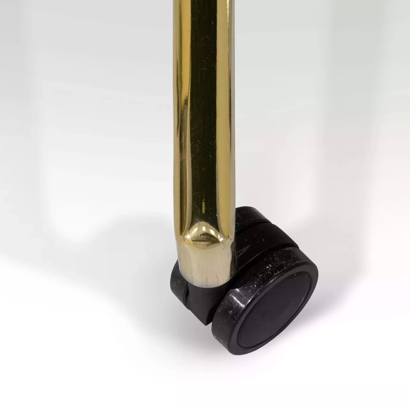 Elegant close-up of one of the black wheels of the golden base of the Hemma Office Chair.
