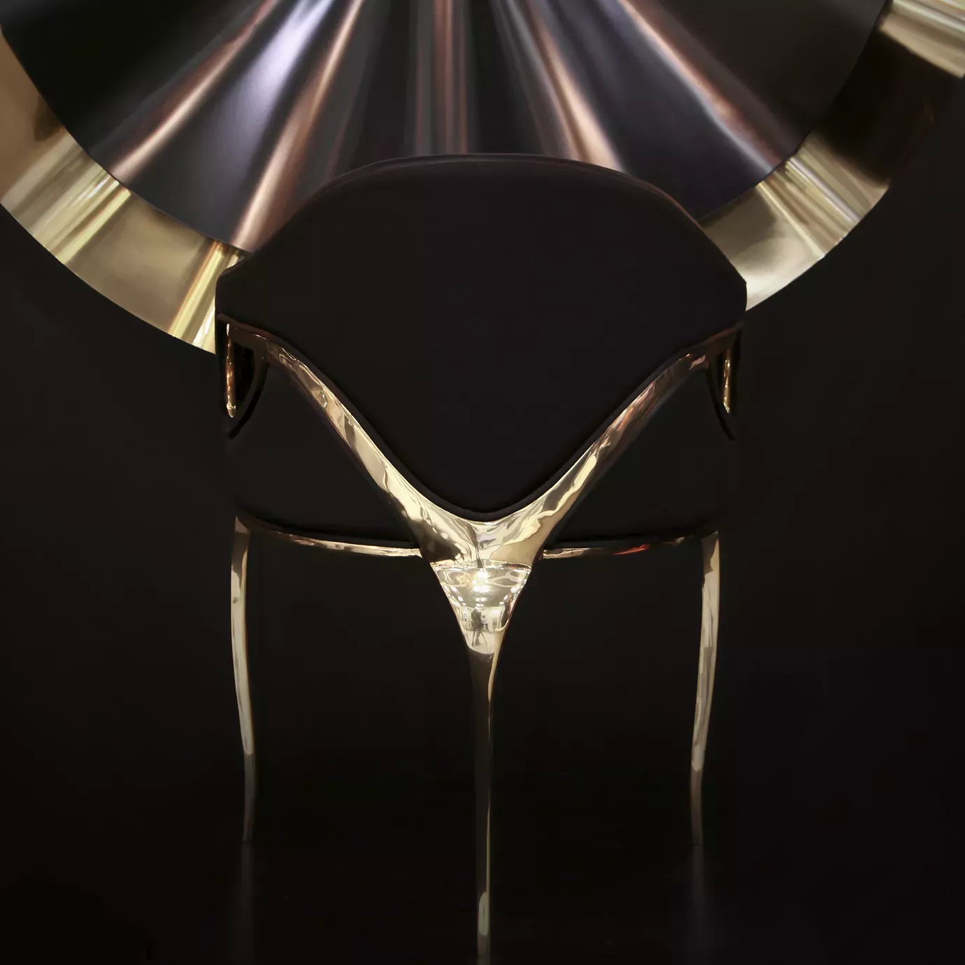 Chandra Chair with a black seat and distinctive golden frame, offering an elegant appearance.