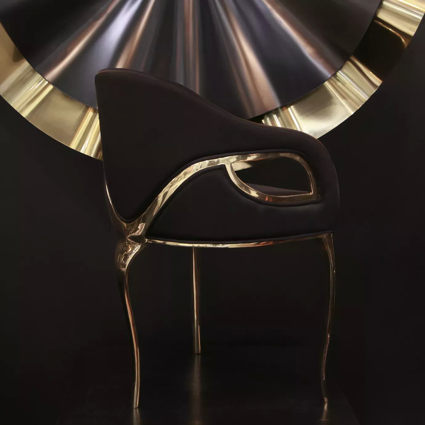 Chandra Chair features a black seat with a distinctive golden frame, giving it an elegant look.