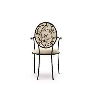 Enchanted Arm Dining Chair: highlighting its elegant aged brass backrest resembling branches, this chair has a luxurious cream upholstery.