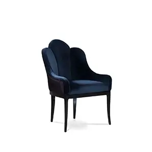 Elegant Anastasia Dining Chair upholstered in deep blue velvet with a textured side detail and dark legs.