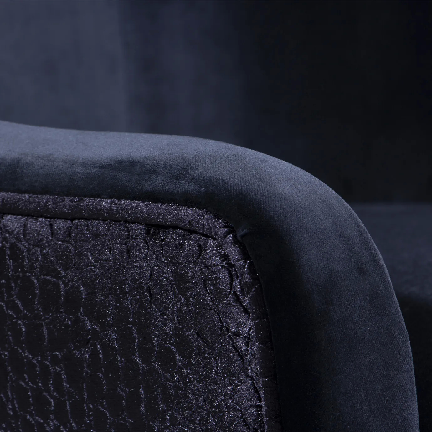 Elegant close-up of the contrast between the deep blue velvet and the textured side detail of the Anastasia Dining Chair.