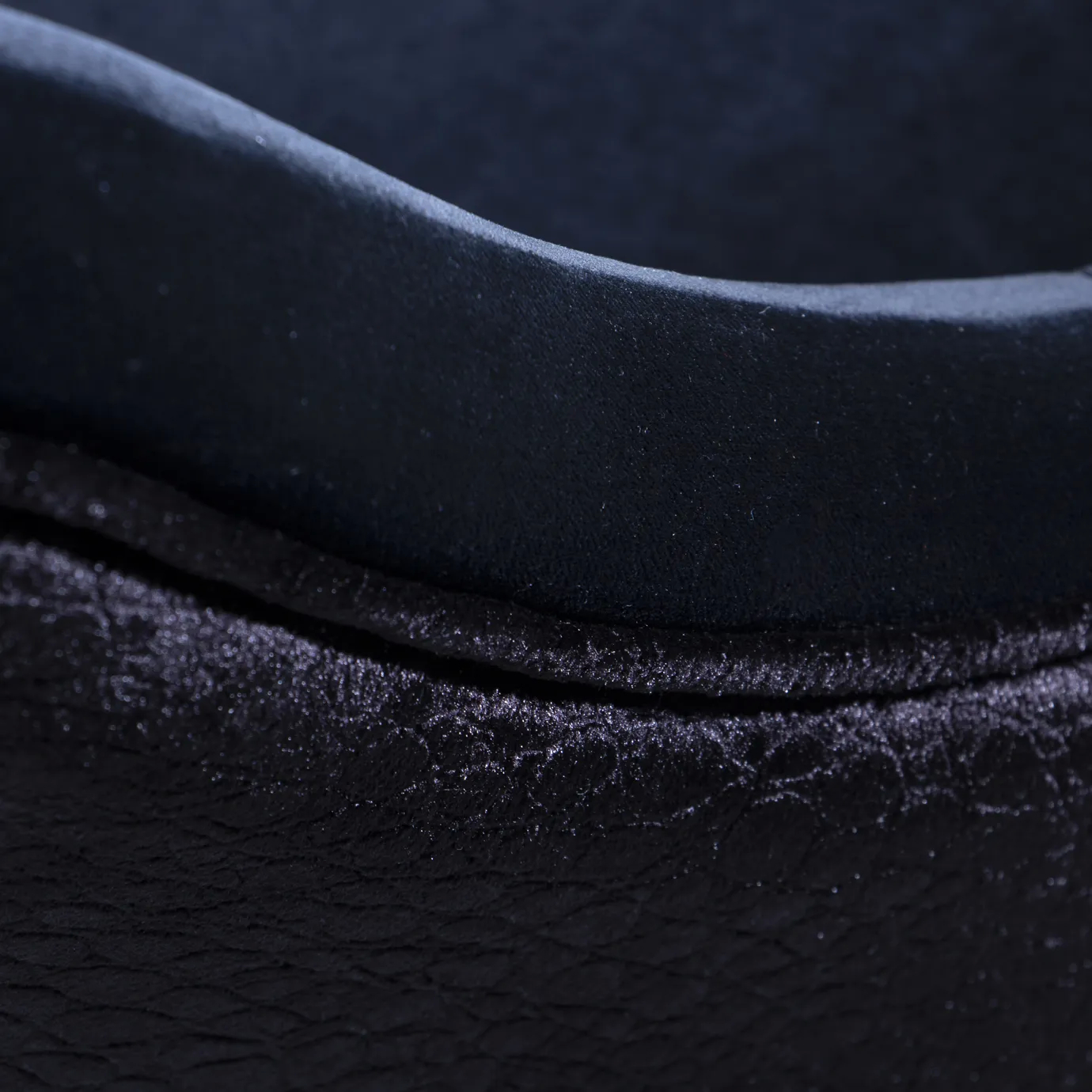 Elegant close-up of the contrast between the deep blue velvet and the textured side detail of the Anastasia Dining Chair.