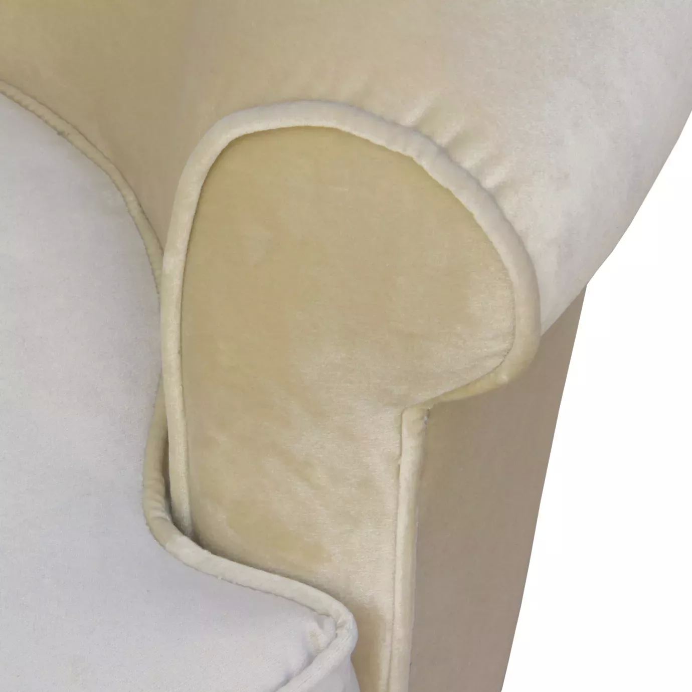 A close-up of the Colette Sofa highlights the soft, light-colored velvet upholstery and the gentle curve of the armrest.