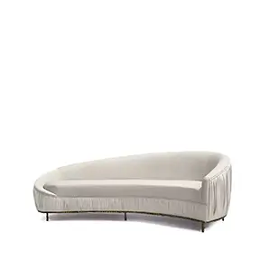 Elegant Vamp Sofa with an ornate golden metal base and cream fabric upholstery with pleated details on one end.